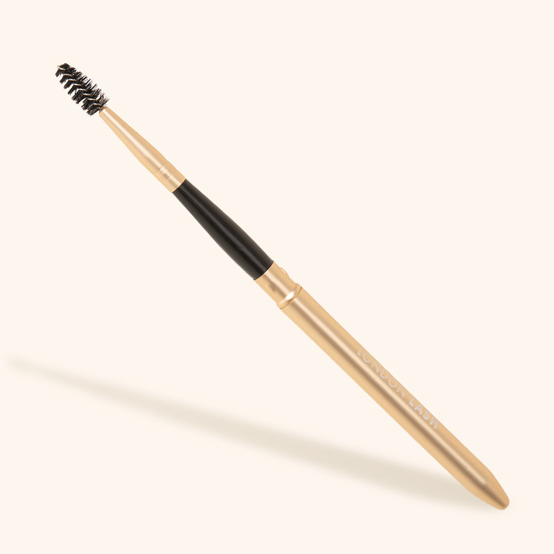 On the Go Lash Wand - reusable eyelash spoolie with a sleek gold handle for precise eyelash application.